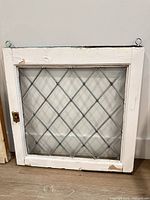 Front view showing full leaded glass window, frame, and hooks