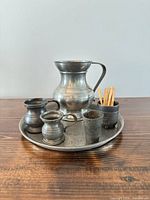 Group shot of all six pewter items on tray