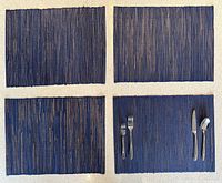 Four blue woven placemats laid out on surface