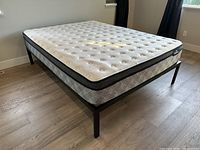 Angled view of Serta Perfect Sleeper mattress on metal frame