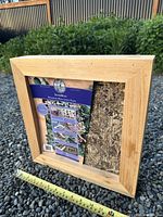 Front view of SuperMoss living frame, packaging insert visible, tape measure shows 14 inch dimension
