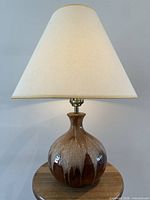 Front view of ceramic lava drip table lamp with shade