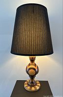 Full view of lamp lit showing shade and base