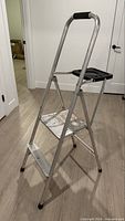 Full view of ladder unfolded showing two steps and platform