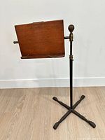 Full view of stand showing mahogany top, brass fittings, metal shaft and cast iron base