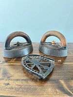 Front view of two sad irons and trivet