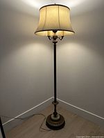 Full view of lit floor lamp with shade