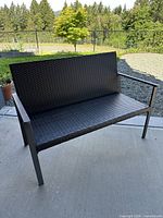Front view of dark brown resin wicker outdoor bench with metal frame