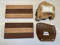Back sides of both striped boards, live-edge slab with maker card, underside of walnut trivet