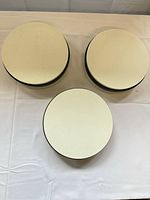 Top view of three off-white rotating turntables with black trim
