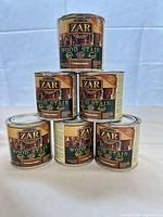 Stacked view showing all six sealed cans and labels
