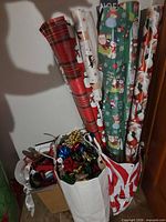 Group of wrapping paper rolls, bows and ribbons