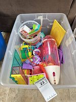 Overview of tote showing mixed plastic playset pieces and red-white fuselage