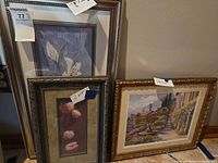 Three framed prints leaning against wall