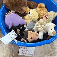 Top view of blue bin full of assorted stuffed animals