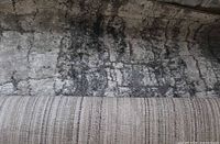 Rolled gray shag rug showing pile texture and pattern