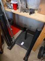 Angled view showing sled base with two tall push posts and central weight post