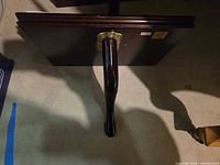 Shelf underside showing turned support post and brass hanger