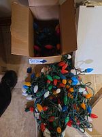Box and tangled strands of multicolour C9 plastic bulb lights