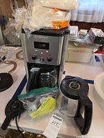Front view of coffee maker with both carafes and filter pack visible