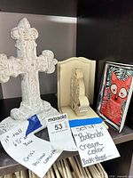 Concrete cream cross, one bookend, fox tray visible on shelf