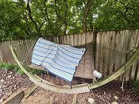Full view of hammock on wooden stand with cushion and cover
