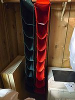 Green and orange hanging organizers with eight compartments each suspended from closet rod