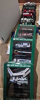 Stack of boxed Hess Mini Collection sets with some vehicles on stands