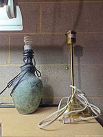 Green patina ceramic IKEA lamp and brass column lamp side by side