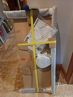 Packaged Philips TV/monitor stand showing boxed components, hardware bag and instructions