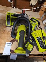 Overall lot showing hedge trimmer, charger and battery on workbench