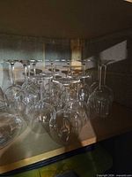group of upside-down clear wine glasses on shelf