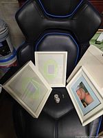 Three of the frames and small decorative hardware pieces on chair