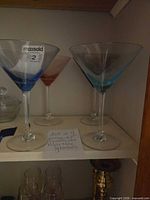 Two front martini glasses in blue and teal hues, showing stems and bowls