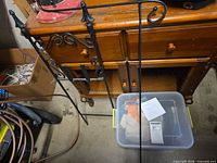 Two black metal garden flag poles leaning against furniture
