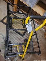 Overhead view of black and yellow mesh steel garden wagon cart