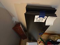 Two stacked black 36 x 8 in shelves with label and hardware bag visible
