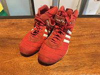 Pair of red Adidas Goodyear sneakers front angle