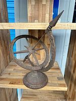 Full view of cast iron armillary sundial on shelf