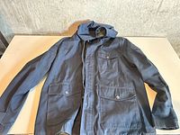 Full view of front of dark blue Dockers hooded jacket showing pockets, zipper, hood
