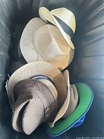 Five assorted hats inside a bin