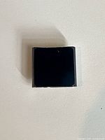 Front view of black glass display on square iPod Nano