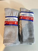 Two factory-packaged grey diabetic crew socks with labels visible