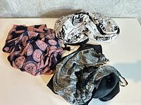 All four scarves spread on table showing patterns and colors