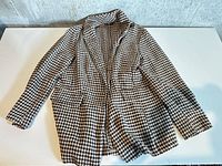 Full view of Shein Curve houndstooth blazer laid flat showing front, sleeves, lapel, pockets