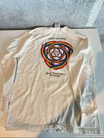 Back of T-shirt showing rainbow spiral graphic and text