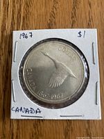 Reverse view of 1967 silver dollar in 2×2 flip showing flying goose design