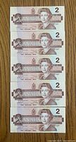 Front view of five sequential 1986 $2 notes