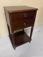 Front view of wood end table showing drawers and lower shelf