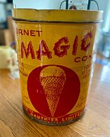 Front view of yellow Magic Cone advertising tin showing graphics